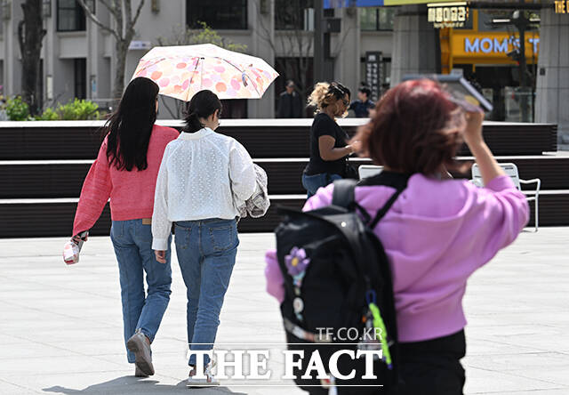 서울의 낮 최고기온이 27도까지 오르는 등 초여름 날씨를 보인 14일 오후 서울 종로구 광화문 광장을 찾은 시민들이 양산을 쓰고 걸음을 옮기고 있다. /박헌우 기자