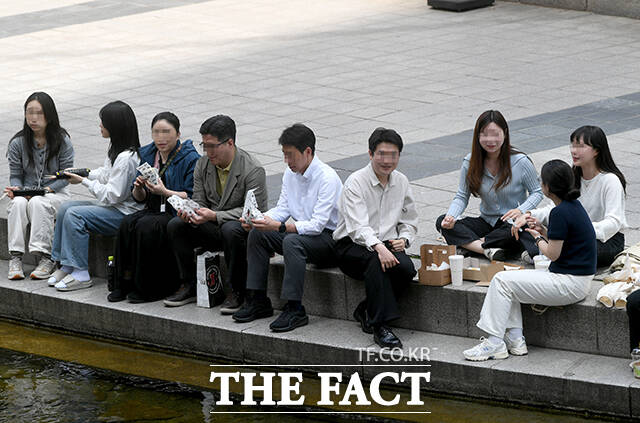 서울 낮 최고 기온이 28도까지 오른 14일 오후 서울 종로구 청계천에서 한 직장인이 청계천에 발을 담그고 있다. /박상민 기자