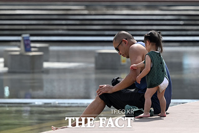 여의도한강공원을 찾은 시민이 물에 발을 담그고 있다.