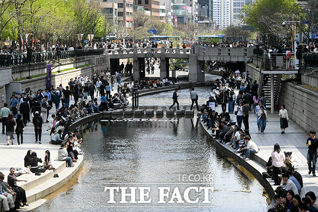 서울 낮 최고 기온이 28도까지 오른 14일 오후 서울 종로구 청계천에서 한 직장인이 청계천에 발을 담그고 있다. /박상민 기자