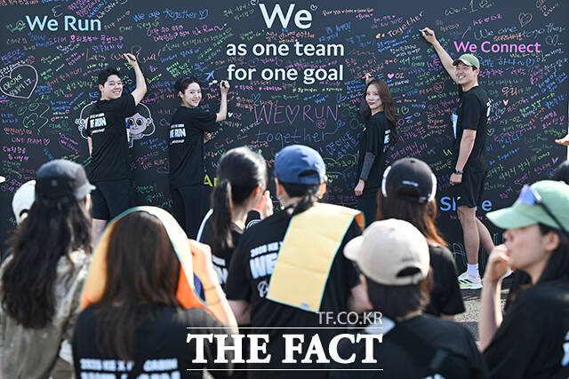 '원팀' 메시지월 앞에서 글귀 남기는 임직원들.