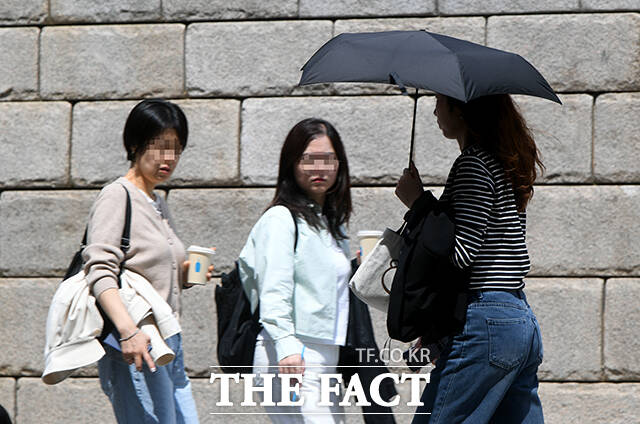 서울 낮 최고 기온이 28도까지 오른 14일 오후 서울 종로구 청계천에서 한 직장인이 청계천에 발을 담그고 있다. /박상민 기자