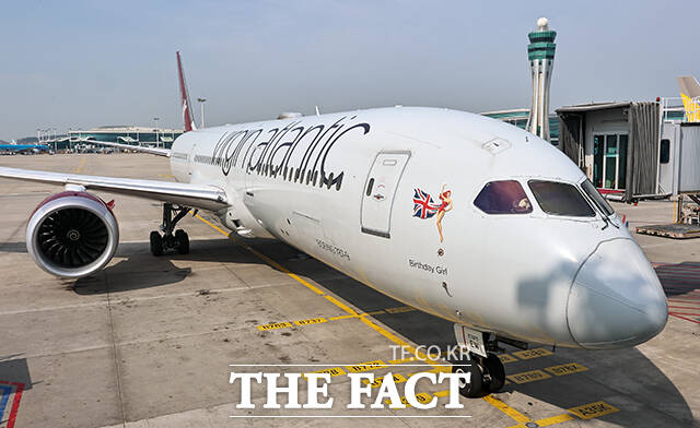 영국 버진애틀랜틱의 런던 히드로발 항공기에서 최고경영자 코닐 코스터(맨 위)와 승무원들이 취항을 기념하며 인사하고 있다. /공항사진기자단