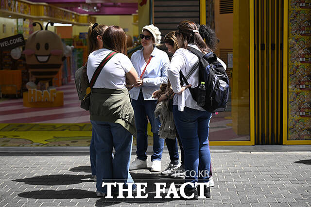 한 외국인 관광객이 음료를 들고 있다.