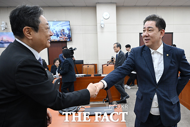 국방위 전체회의 참석해 황희 더불어민주당 의원과 인사 나누는 김병기 무소속 의원(오른쪽).