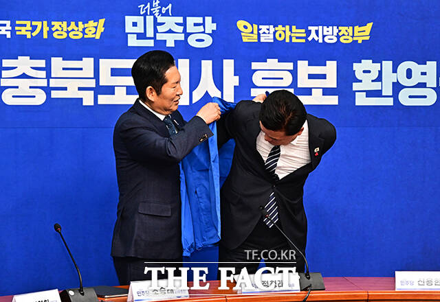 정청래 더불어민주당 대표(왼쪽)가 14일 오후 서울 여의도 국회에서 열린 신용한 충북도지사 후보 환영식에 참석해 신 후보에게 파란색 당 점퍼를 입혀주고 있다. /국회=배정한 기자