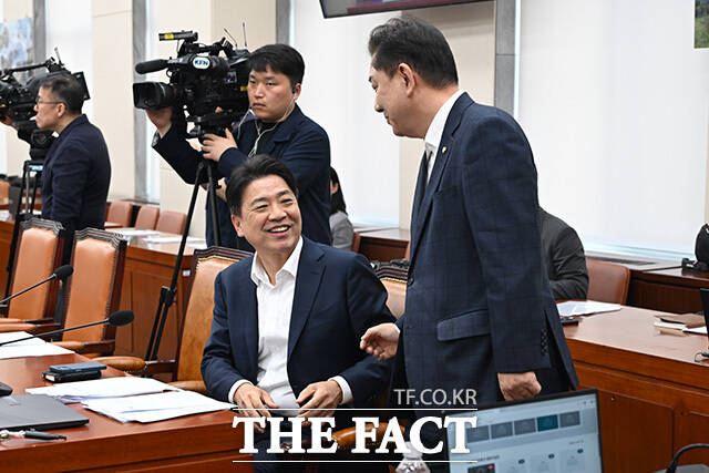 국방위 전체회의 참석해 황희 더불어민주당 의원과 인사 나누는 김병기 무소속 의원(오른쪽).