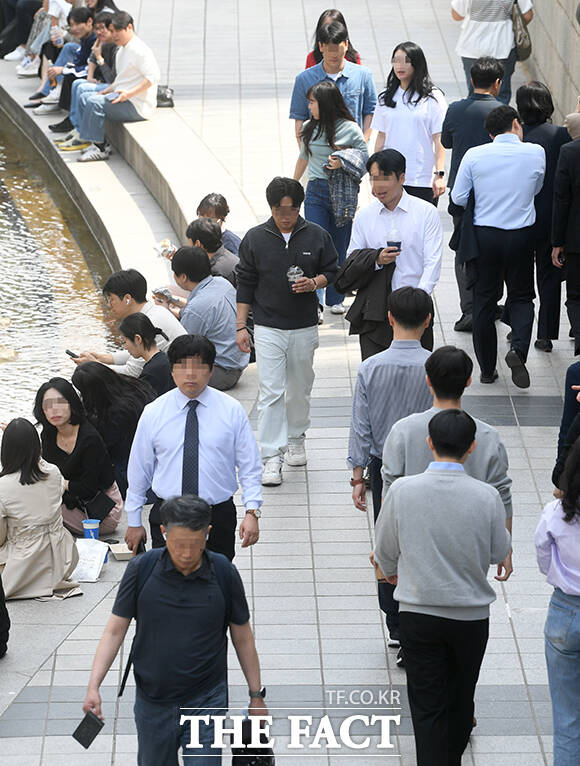 서울 낮 최고 기온이 28도까지 오른 14일 오후 서울 종로구 청계천에서 한 직장인이 청계천에 발을 담그고 있다. /박상민 기자