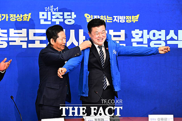 정청래 더불어민주당 대표(왼쪽)가 14일 오후 서울 여의도 국회에서 열린 신용한 충북도지사 후보 환영식에 참석해 신 후보에게 파란색 당 점퍼를 입혀주고 있다. /국회=배정한 기자