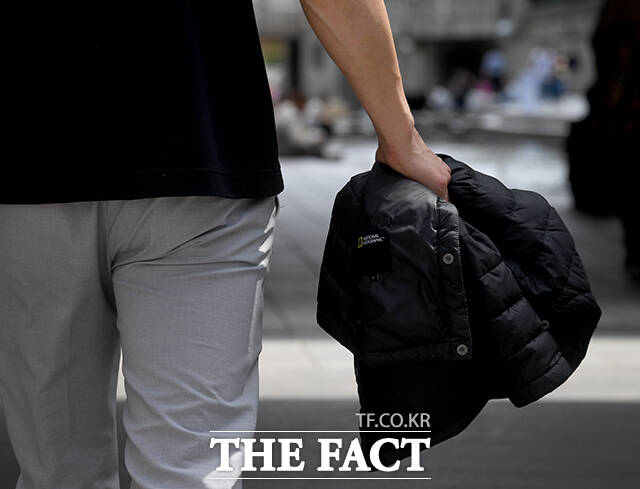 서울 낮 최고 기온이 28도까지 오른 14일 오후 서울 종로구 청계천에서 한 직장인이 청계천에 발을 담그고 있다. /박상민 기자