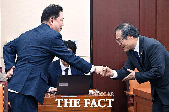 국방위 전체회의 참석해 황희 더불어민주당 의원과 인사 나누는 김병기 무소속 의원(오른쪽).