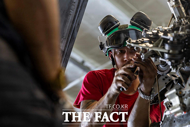 미 해군 장병이 아라비아해를 항해 중인 USS 에이브러햄 링컨(CVN 72) 항공모함에서 MH-60 시호크 헬기를 정비하고 있다.