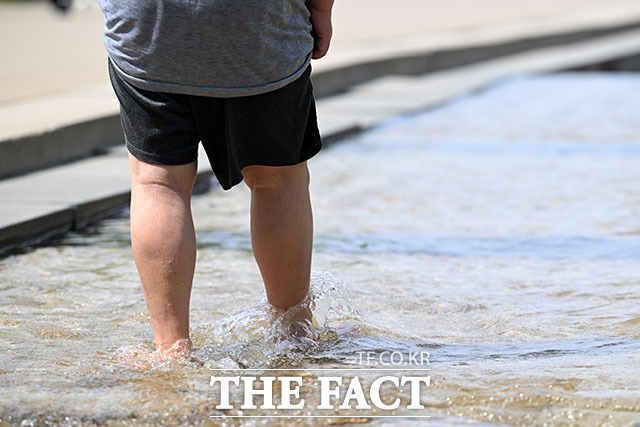 여의도한강공원을 찾은 시민이 물에 발을 담그고 있다.