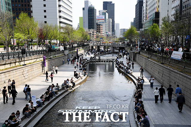 서울 낮 최고 기온이 28도까지 오른 14일 오후 서울 종로구 청계천에서 한 직장인이 청계천에 발을 담그고 있다. /박상민 기자