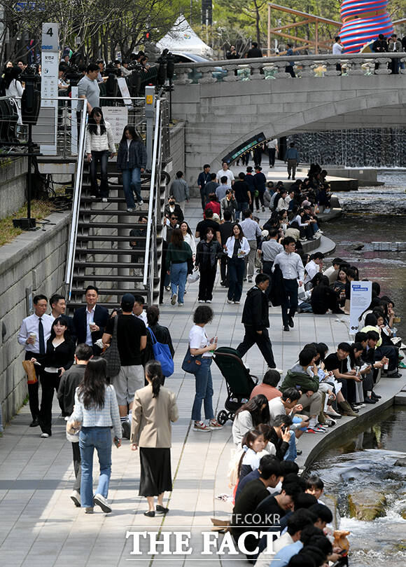서울 낮 최고 기온이 28도까지 오른 14일 오후 서울 종로구 청계천에서 한 직장인이 청계천에 발을 담그고 있다. /박상민 기자