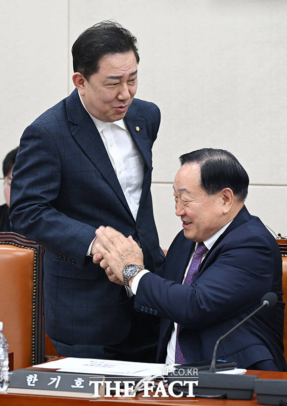 국방위 전체회의 참석해 황희 더불어민주당 의원과 인사 나누는 김병기 무소속 의원(오른쪽).