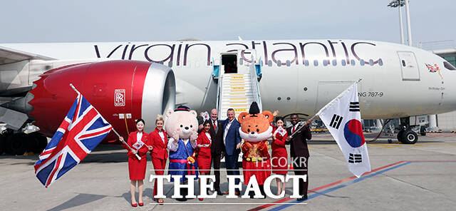 영국 버진애틀랜틱의 런던 히드로발 항공기에서 최고경영자 코닐 코스터(맨 위)와 승무원들이 취항을 기념하며 인사하고 있다. /공항사진기자단