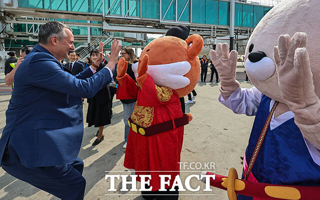영국 버진애틀랜틱의 런던 히드로발 항공기에서 최고경영자 코닐 코스터(맨 위)와 승무원들이 취항을 기념하며 인사하고 있다. /공항사진기자단