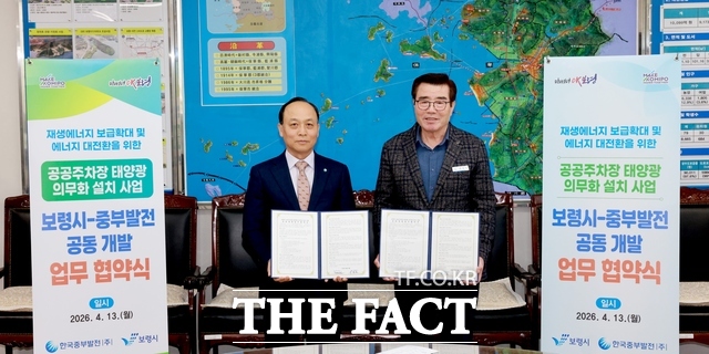 이영조 한국중부발전 사장(왼쪽)과 김동일 보령시장이 13일 열린 '공공주차장 태양광 의무화 설치사업' 협약식에서 협약서를 들고 기념 촬영을 하고 있다. /보령시