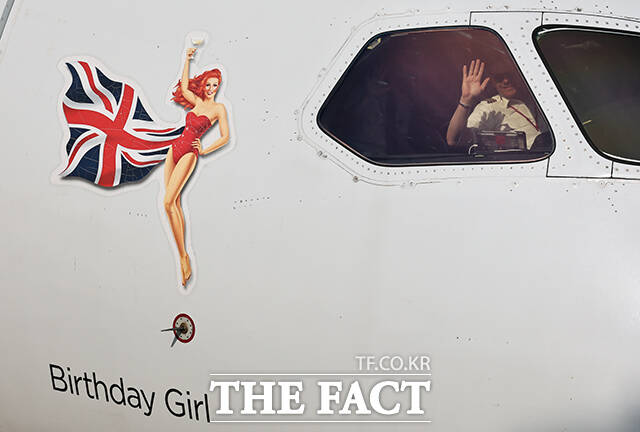 영국 버진애틀랜틱의 런던 히드로발 항공기에서 최고경영자 코닐 코스터(맨 위)와 승무원들이 취항을 기념하며 인사하고 있다. /공항사진기자단