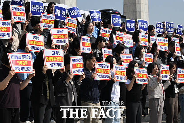 송언석 국민의힘 원내대표(앞줄 왼쪽에서 다섯 번째)와 정점식 정책위의장, 조지연 약자와의동행위원회 위원장 등이 15일 오전 서울 여의도 국회 본관 앞 계단에서 열린 '특수교육법 개정을 통한 선제적 장애 영유아 유보통합 시행 촉구대회'에 참석해 구호를 외치고 있다. /국회=김성렬 기자