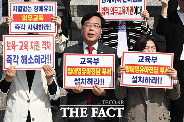 송언석 국민의힘 원내대표(앞줄 왼쪽에서 다섯 번째)와 정점식 정책위의장, 조지연 약자와의동행위원회 위원장 등이 15일 오전 서울 여의도 국회 본관 앞 계단에서 열린 '특수교육법 개정을 통한 선제적 장애 영유아 유보통합 시행 촉구대회'에 참석해 구호를 외치고 있다. /국회=김성렬 기자