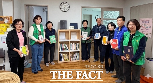 군위군새마을회는 최근 마을마다 작은 도서관을 조성하기 위해 지역 내 경로당 215곳에 도서 3870권과 전용 책장을 지원했다. 관계자들이 기념사진을 찍고 있다. /군위군
