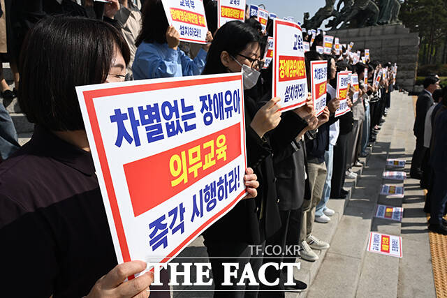 송언석 국민의힘 원내대표(앞줄 왼쪽에서 다섯 번째)와 정점식 정책위의장, 조지연 약자와의동행위원회 위원장 등이 15일 오전 서울 여의도 국회 본관 앞 계단에서 열린 '특수교육법 개정을 통한 선제적 장애 영유아 유보통합 시행 촉구대회'에 참석해 구호를 외치고 있다. /국회=김성렬 기자