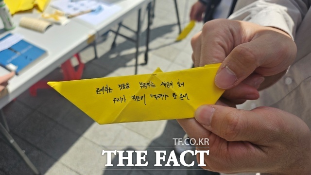 서울대 학생 홍성민(20) 씨가 16일 '나에게 세월호란' 질문에 관해 직접 접은 종이배 위에 적은 글귀를 보여주고 있다./ 강주영