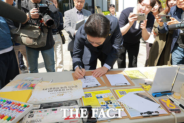 추모를 마친 뒤 방명록을 작성하는 정 후보.