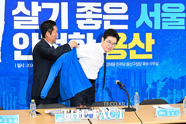 정청래 더불어민주당 대표(왼쪽)가 17일 오전 서울 용산구에 마련된 강태웅 용산구청장 후보 선거사무소에서 열린 현장 최고위원회의에서 정원오 서울시장 후보에게 당 점퍼를 입혀주고 있다. /박헌우 기자