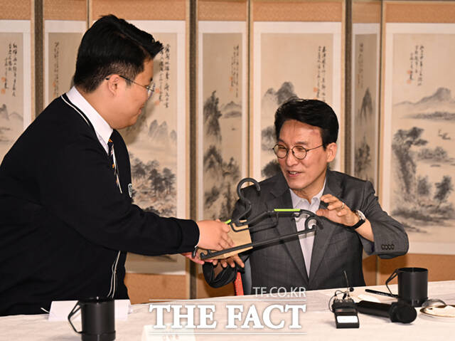 김민석 국무총리가 18일 오후 서울 삼청동 총리공관에서 열린 서울 당현초 환경동아리 학생 등 초·중·고 환경동아리, 청년 기후활동 단체와 간담회에서 청소년 대표로부터 병뚜껑 재활용 옷걸이와 다회용컵을 선물받고 있다. /이새롬 기자