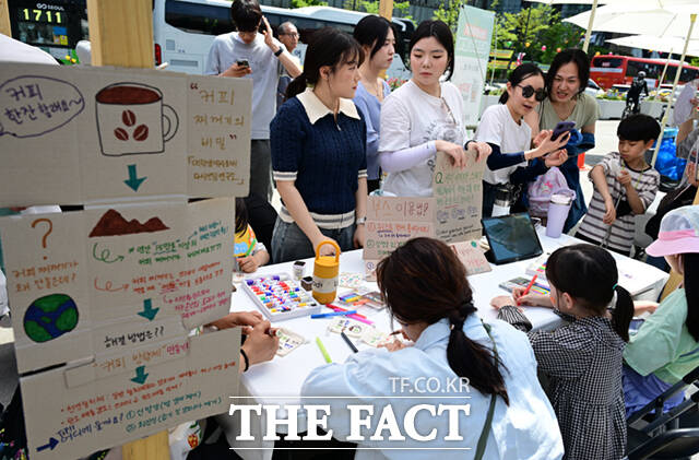 18일 서울 광화문 광장에서 서울시와 녹색서울시민위원회 주최로 '2026 지구의 날 기념행사'가 열린 가운데, 행사를 찾은 배우 김석훈(오른쪽)이 부스를 체험하고 있다.