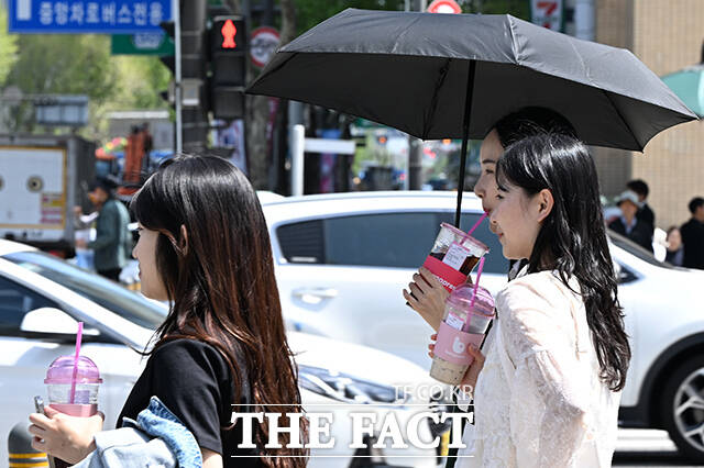 지난 16일 오후 서울 종로구 세종대로 일대에서 시민들이 양산을 쓰고 음료를 든 채 걸어가고 있다. /김성렬 기자