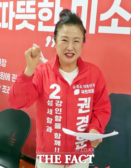 권경운 국민의힘 공주시의원 후보가 자신의 현수막 앞에서 파이팅을 외치고 있다. /김형중 기자
