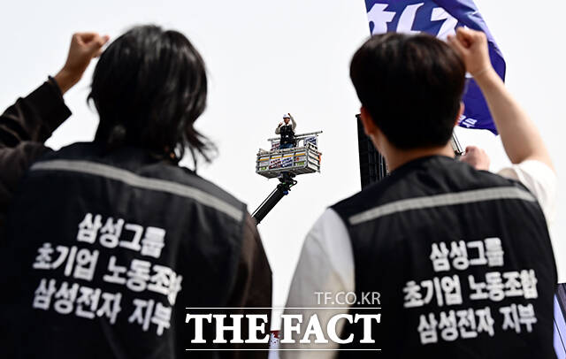 23일 오후 경기 삼성전자 평택캠퍼스 앞에서 열린 '4.23 투쟁 결의대회'에 참석한 초기업노조 삼성전자 지부 조합원들이 크레인 위에서 발언하는 최승호 삼성전자 지부 위원장을 바라보고 있다. /평택=임영무 기자