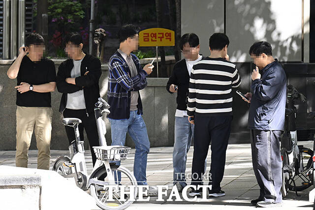 시민들이 금연 구역에서 흡연을 하고 있다.