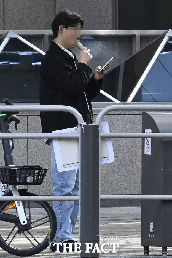 시민들이 금연 구역에서 흡연을 하고 있다.