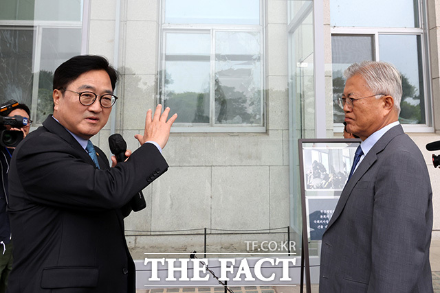 우원식 의장(왼쪽)에게 계엄군이 진입한 국회 의사당의 깨진 창문에 대한 설명 듣는 문 전 대통령.