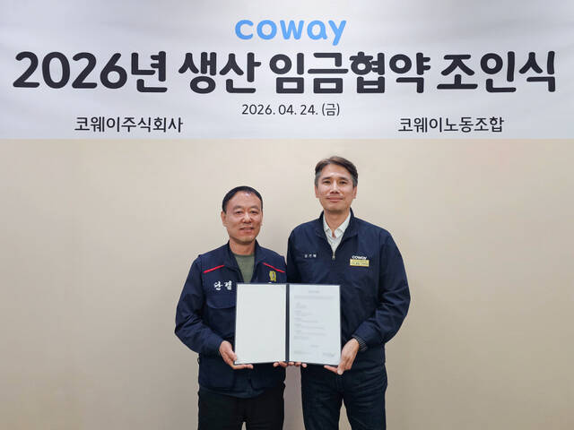 김기배 코웨이 생산구매본부장(오른쪽부터)과 임재환 생산 코웨이노동조합 위원장이 지난 24일 충청남도 공주시에 위치한 유구공장에서 '2026년 임금협약 조인식'을 진행하고 기념 촬영을 하고 있다. /코웨이