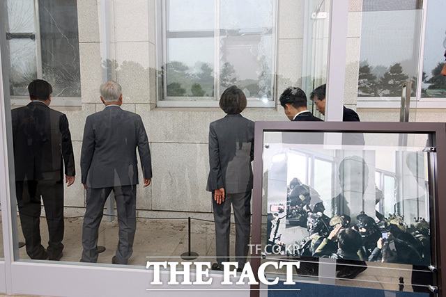 우원식 의장(왼쪽)에게 계엄군이 진입한 국회 의사당의 깨진 창문에 대한 설명 듣는 문 전 대통령.