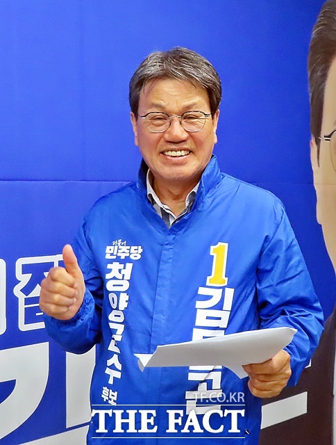 김돈곤 후보가 자신의 현수막 앞에서 파이팅을 외치고 있다. /김형중 기자