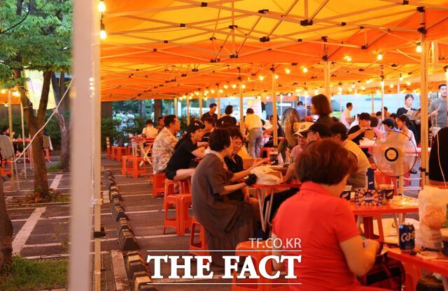 2024대구치맥페스티벌 참가자들이 그늘막이 아래에서 치킨과 맥주를 즐기고 있다./더팩트DB