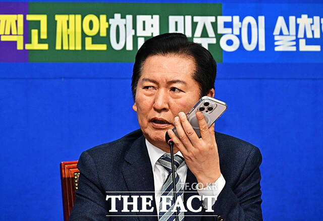 13호 공약을 제안한 시장 상인과 통화하는 정청래 대표.