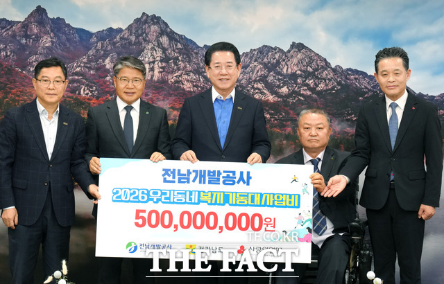 김영록 전라남도지사(가운데)가 27일 도청 접견실에서 장충모 전남개발공사장(왼쪽 두 번째)으로부터 우리동네 복지기동대 등 지역 복지사업 지원을 위한 지원금 5억 원을 기탁받고 있다. /전남도