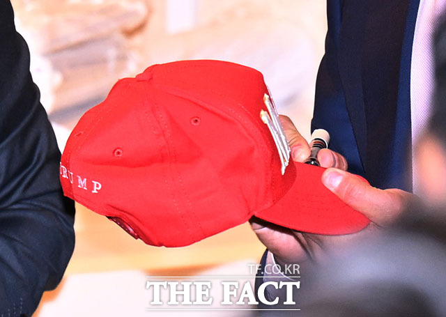 트럼프 이름이 적힌 빨간 'MAGA' 모자 발견하고 발걸음 돌리는 트럼프 주니어.