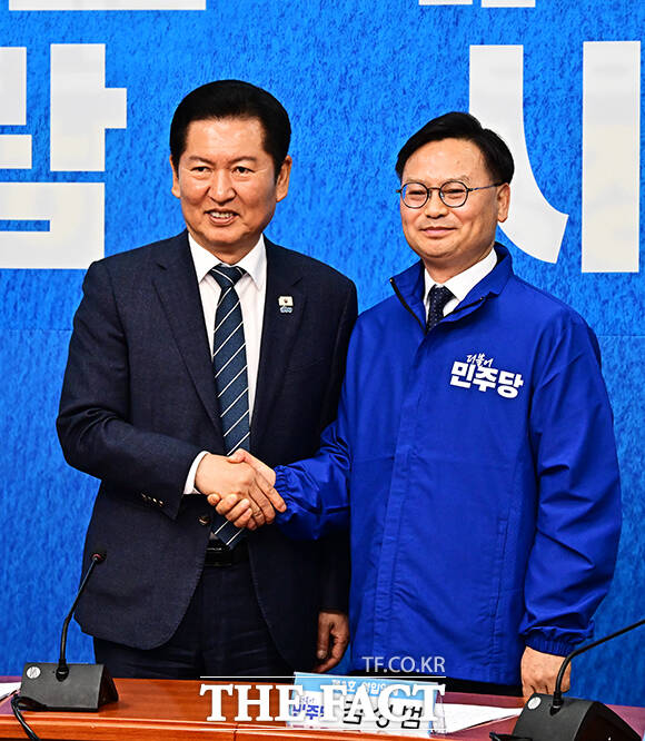 정청래 더불어민주당 대표(왼쪽)가 30일 오전 서울 여의도 국회에서 열린 3차 인재영입식에 참석해 6.3 재보궐선거 제주 서귀포시 후보로 영입한 김성범 전 해수부 차관에게 파란색 점퍼를 입혀주고 있다. /국회=배정한 기자