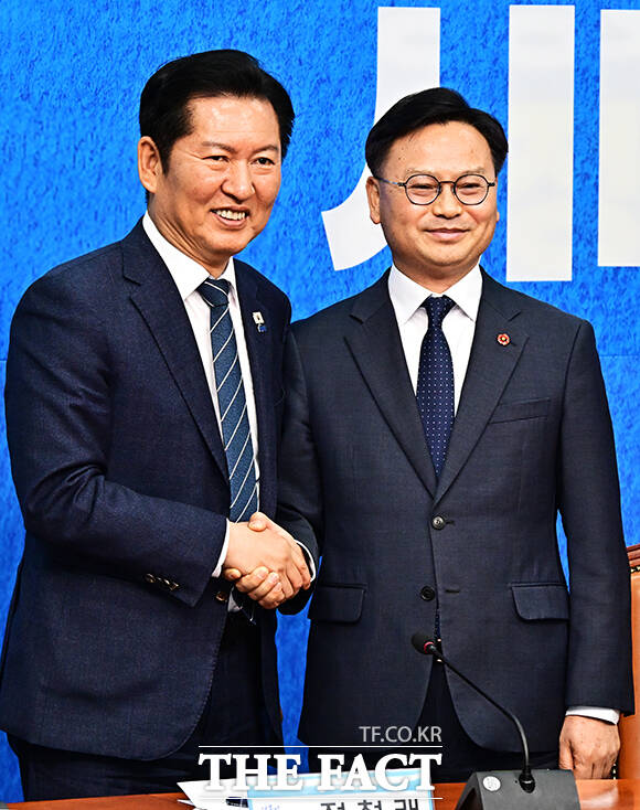 정청래 더불어민주당 대표(왼쪽)가 30일 오전 서울 여의도 국회에서 열린 3차 인재영입식에 참석해 6.3 재보궐선거 제주 서귀포시 후보로 영입한 김성범 전 해수부 차관에게 파란색 점퍼를 입혀주고 있다. /국회=배정한 기자