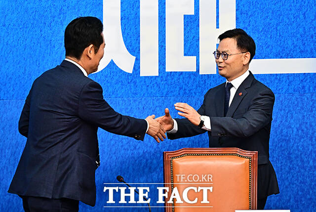 정청래 더불어민주당 대표(왼쪽)가 30일 오전 서울 여의도 국회에서 열린 3차 인재영입식에 참석해 6.3 재보궐선거 제주 서귀포시 후보로 영입한 김성범 전 해수부 차관에게 파란색 점퍼를 입혀주고 있다. /국회=배정한 기자