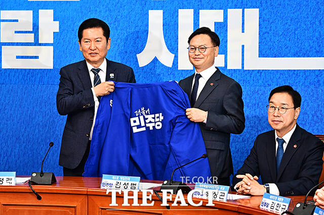 정청래 더불어민주당 대표(왼쪽)가 30일 오전 서울 여의도 국회에서 열린 3차 인재영입식에 참석해 6.3 재보궐선거 제주 서귀포시 후보로 영입한 김성범 전 해수부 차관에게 파란색 점퍼를 입혀주고 있다. /국회=배정한 기자